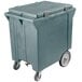 A large slate blue plastic container on wheels.