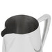 A Vollrath stainless steel water pitcher with a handle.