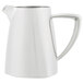 A close-up of a stainless steel Vollrath creamer with a white handle.