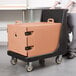 A man pushing a Cambro front loading insulated tray carrier on a cart.