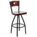 A BFM Seating black metal bar stool with a mahogany wooden swivel seat.