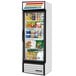 A white True refrigerated glass door merchandiser full of food including bread, candy, and beverages.