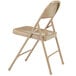 A beige National Public Seating metal folding chair.
