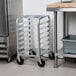 A Channel stainless steel rolling sheet pan rack with trays on it.