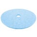 A blue Scrubble burnishing pad with a white center.