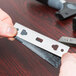 A person holding a Unger ErgoTec Ninja stainless steel glass scraper blade.