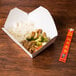 A white Fold-Pak Bio-Pak take-out box filled with rice and chicken on a table.