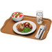 A Cambro rectangular fiberglass tray with a plate of food, a bowl of salad, and a glass of water with a lemon slice on it.