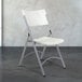 A National Public Seating white folding chair with a gray speckled seat and back.