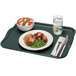 A Cambro rectangular slate blue fiberglass cafeteria tray with food, a fork, and a knife on a napkin.