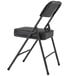 A National Public Seating black steel folding chair with black vinyl padding.