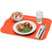 A Cambro citrus orange rectangular fiberglass tray with a plate of food and a bowl of salad on it.