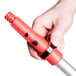 A hand holding a red Unger ErgoTec locking cone.