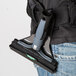 A person wearing a black and grey Unger ErgoTec Ninja scraper holster attached to a black belt.