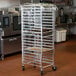 A metal bun pan rack with clear plastic covering it.