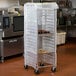 A Regency plastic cover on a food storage rack full of trays of cookies.