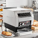 A Hatco Toast Qwik conveyor toaster on a counter with bread in it.