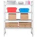 A white Cambro Camshelving® Premium shelving unit with vented shelves holding brown boxes and blue and red containers.