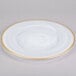 A white Charge It by Jay alabaster glass charger plate with a gold rim.