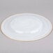 A white Charge It by Jay glass charger plate with a gold rim.