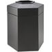 A black hexagonal waste container with an open top.