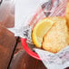 American Metalcraft newspaper deli wrap with fried fish and a lemon wedge on a plate.