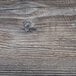 A close up of a wood surface with scratches and cracks.