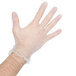 A hand wearing a clear plastic glove using an Unger Trash Removal Kit.