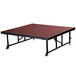A rectangular National Public Seating Transfix stage platform with red carpet on wheels.