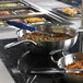 A school kitchen counter with pans of food on a Vollrath Mirage Induction Warmer.