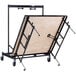 A National Public Seating Transfix adjustable stage with hardboard top on wheels.