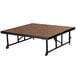 A National Public Seating Transfix stage platform with wheels and brown hardboard surface.