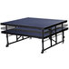 A National Public Seating Transfix stage platform with blue carpet and black metal legs.