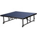 A blue rectangular National Public Seating Transfix stage platform with wheels.