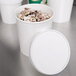 A white Choice paper cup with a lid filled with ice cream.