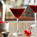 A table with two glasses of red Monin Black Cherry fruit puree cocktails.