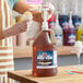 A gallon jug of Carnival King Tamarind Snow Cone Flavoring Syrup with a pump dispenser.