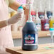 A gallon jug of Carnival King Bubble Gum Snow Cone Flavoring Syrup with a pump dispenser.