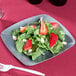 A Fineline silver square plastic salad plate with salad, strawberries, and spinach.