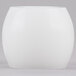 A white round wax hurricane candle on a white base.