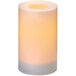 A Sterno white flameless pillar candle with a yellow light inside.