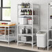 A white Cambro Camshelving Premium unit with 5 vented shelves holding food items.