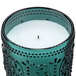 A Sterno teal flameless wax filled glass lamp on a white base.