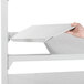 A person adding a white Camshelving® Premium unit shelf.