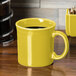 A Fiesta Sunflower china java mug on a table.