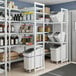 A white Cambro Camshelving unit with 4 vented shelves and 1 solid shelf.