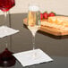 A Stolzle flute glass filled with champagne sits on a table.