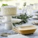 A white cake on a table with Bambu disposable square bamboo plates and forks.