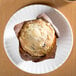 An American Metalcraft melamine plate with a muffin in a brown wrapper.