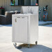 A silver Crown Verity portable hand sink cart with a white bowl.